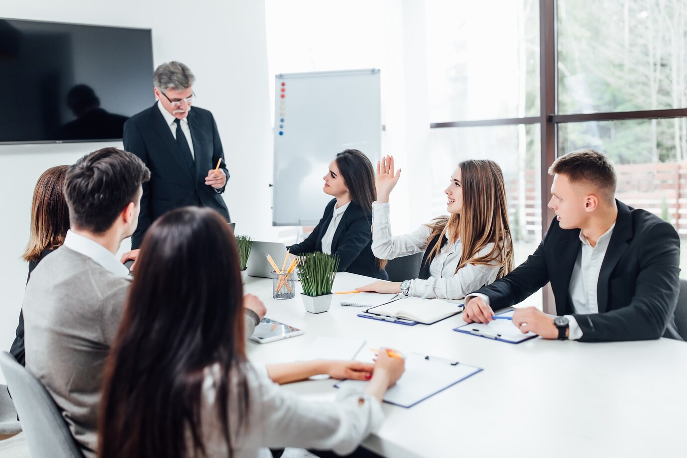 Boss businessman holding papers hands and smiling.Young team of coworkers making great business discussion in modern coworking office.
